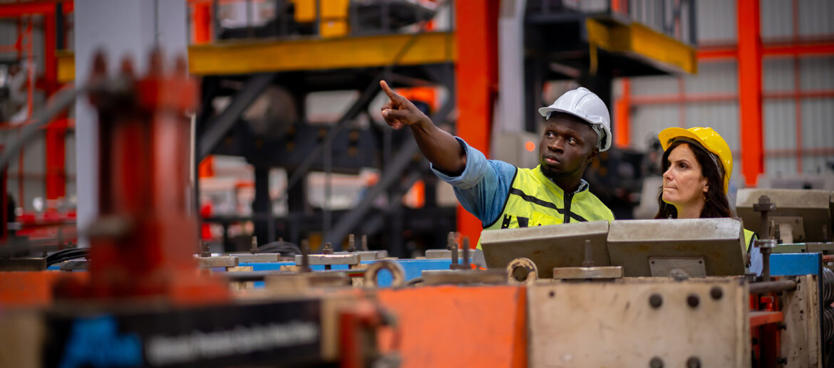 Team of young male and female engineers in a metal sheet factory Responsible work is being inspected at the actual work site. Work professionally and happily